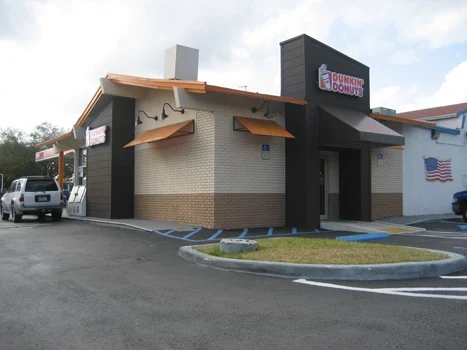 Dunkin’ Donuts building with orange awnings and an adjoining parking area