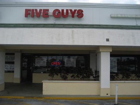 Five Guys sign above a shaded restaurant entrance