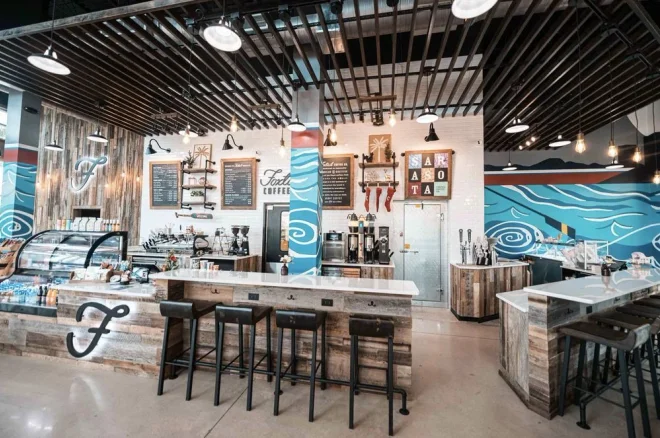 Foxtail Coffee Sarasota interior with a long service counter, stools and exposed ceiling