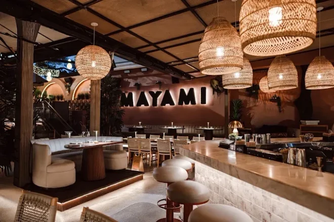 Mayami Wynwood dining room with woven pendant lights and warm wood finishes