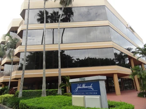 Multi-story office building with reflective windows and landscaping