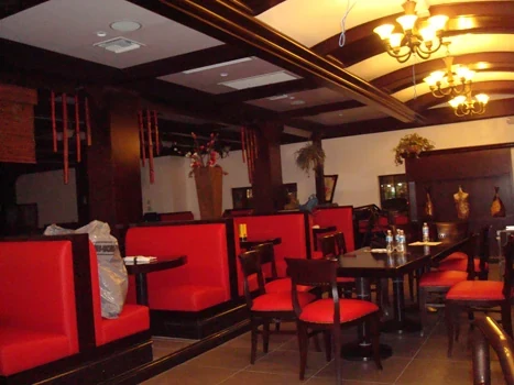 Restaurant dining area with red booth seating and decorative ceiling lights