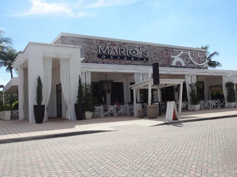 Restaurant entrance with columns, decorative facade details, and outdoor tables