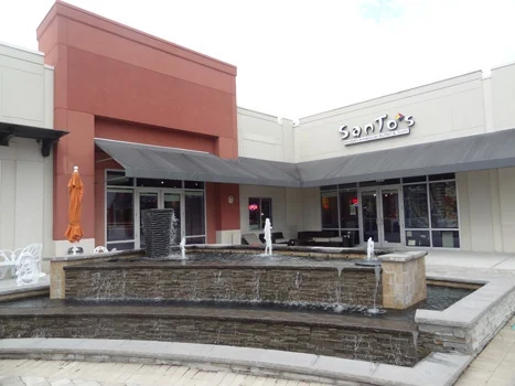 Restaurant storefront with a raised outdoor patio and stone retaining wall