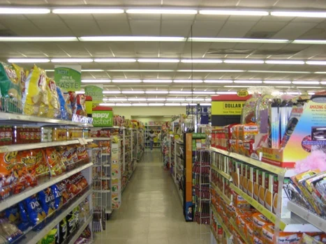 Retail merchandise aisles beneath rows of overhead lighting