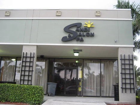 Salon and spa storefront with a central entrance and planted beds