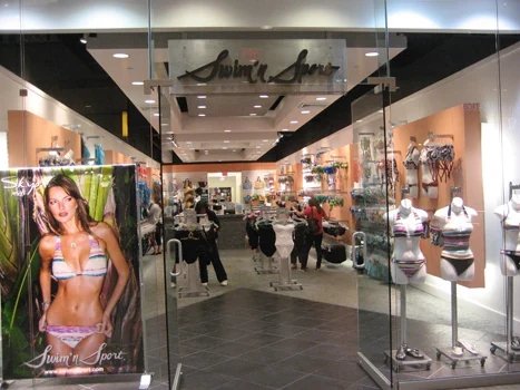 Swimwear store entrance with merchandise displays and ceiling lighting